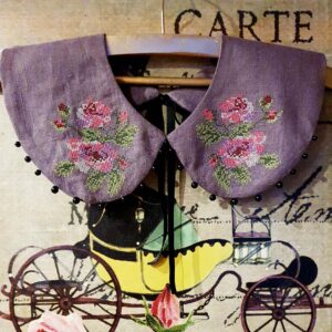 Lilla roositikandiga linane krae, kaunistuseks allääres mustad pärlid.